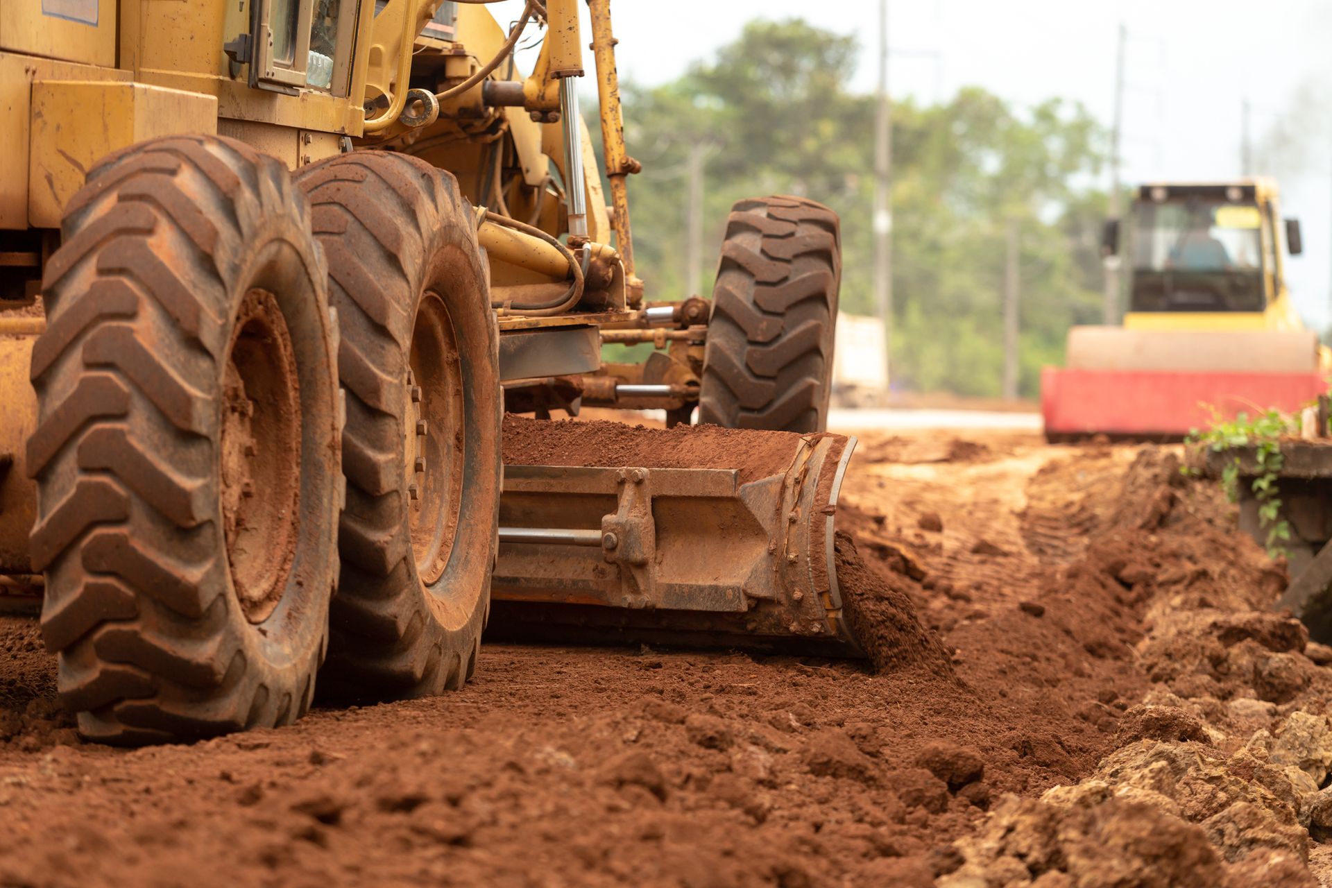 A bulldozer is moving dirt on a dirt road.
