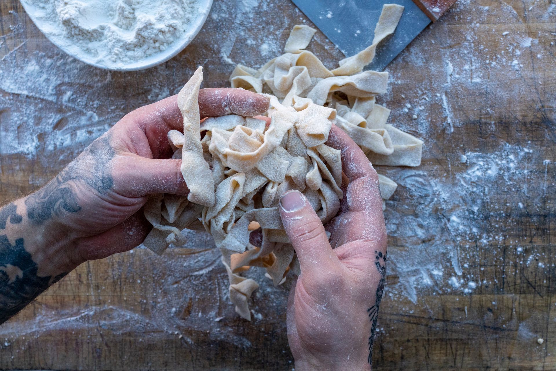 A person is holding a pile of noodles in their hands.