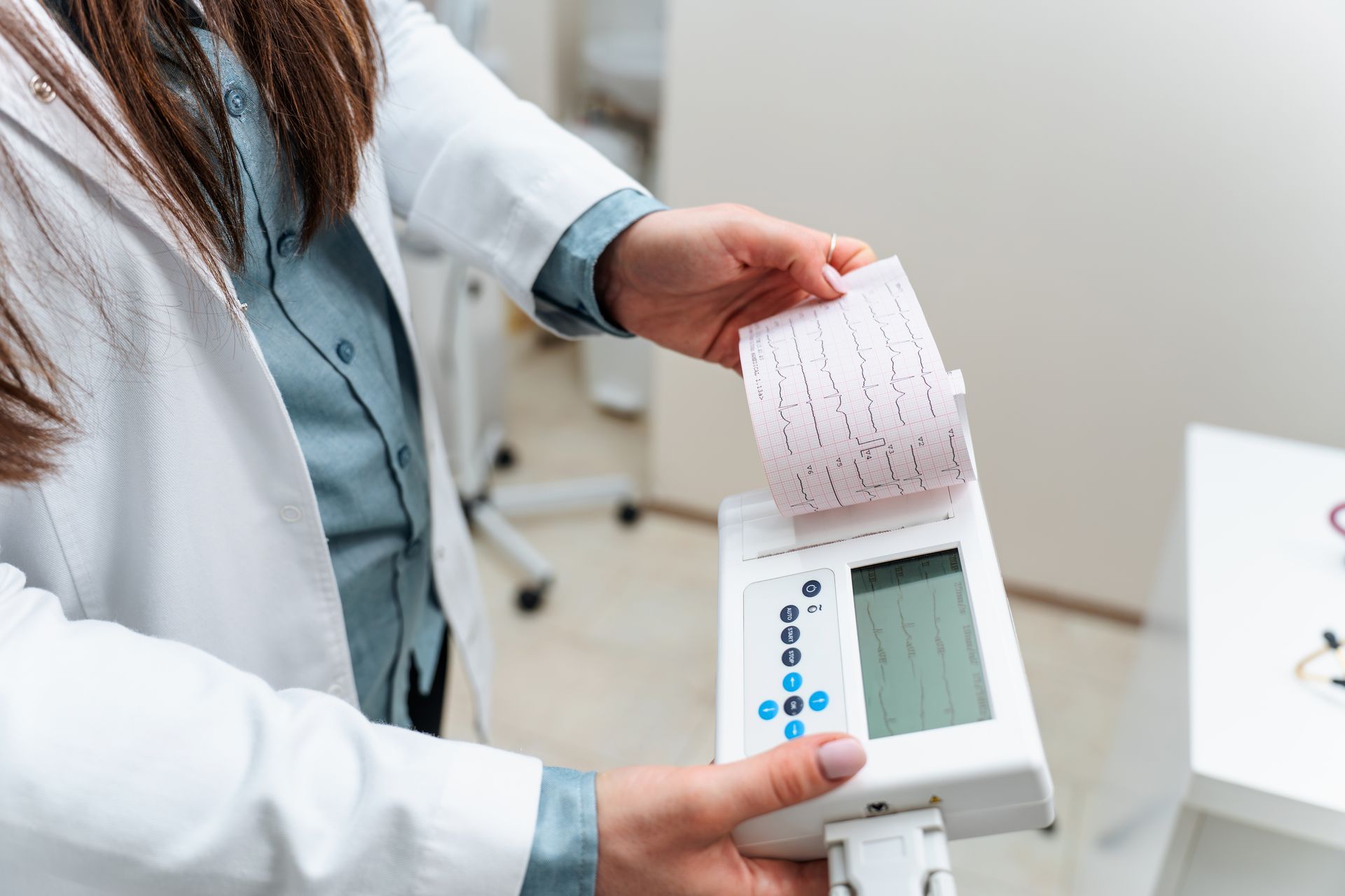 Person using a blood pressure monitor with a printed reading in a clinical setting Person using a blood pressure monitor with a printed reading in a clinical setting