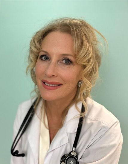 Smiling doctor in a white coat with a stethoscope against a white background Smiling doctor in a white coat with a stethoscope against a white background
