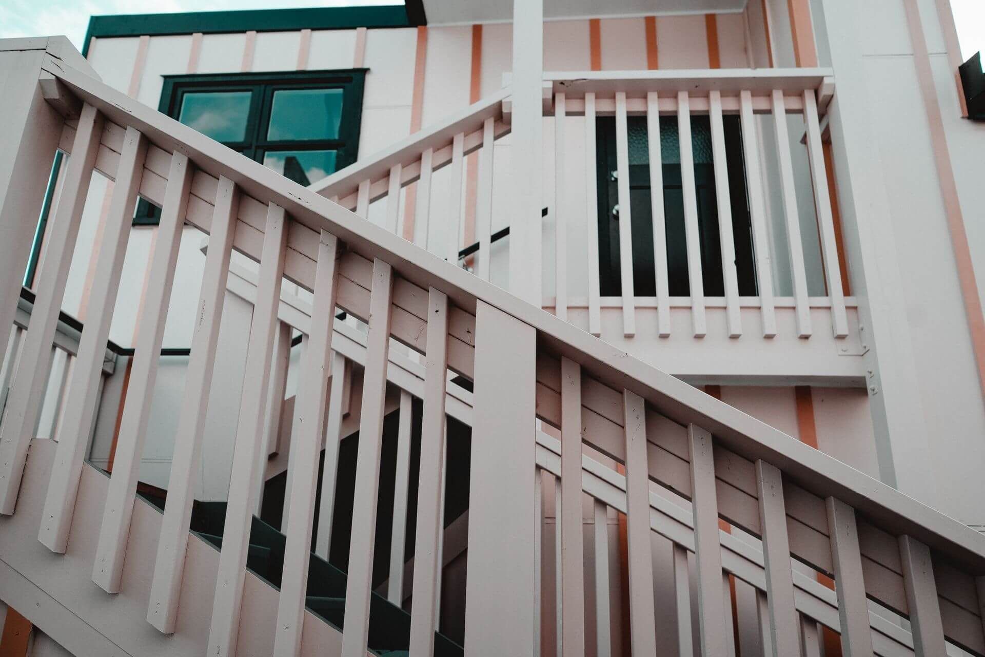 A set of stairs leading up to a balcony on the side of a building.