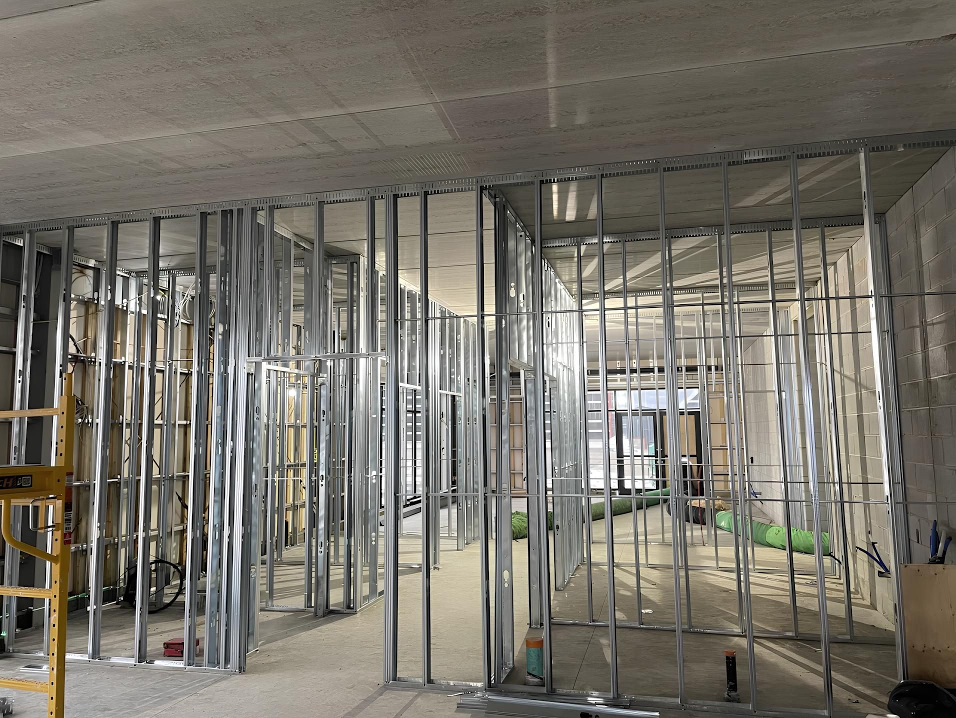 Metal studs forming interior walls in a construction site, with exposed ceiling.