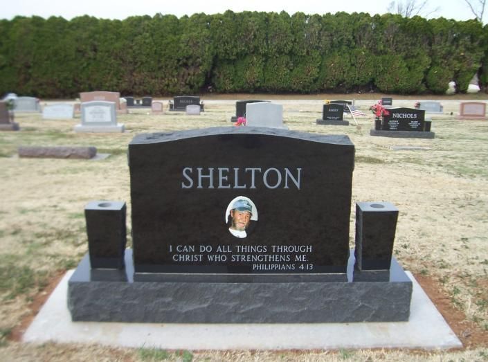 Black gravestone with “SHELTON” in a cemetery, with a small photo and engraved verse.