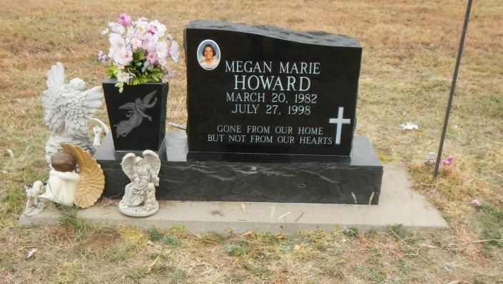 Gravestone with flowers, angel figurine, and decorative bird in a small memorial garden