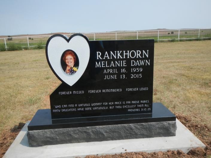 Heart-shaped gravestone with a portrait, reading “Rankhorn Melanie Dawn,” in a grassy cemetery field.