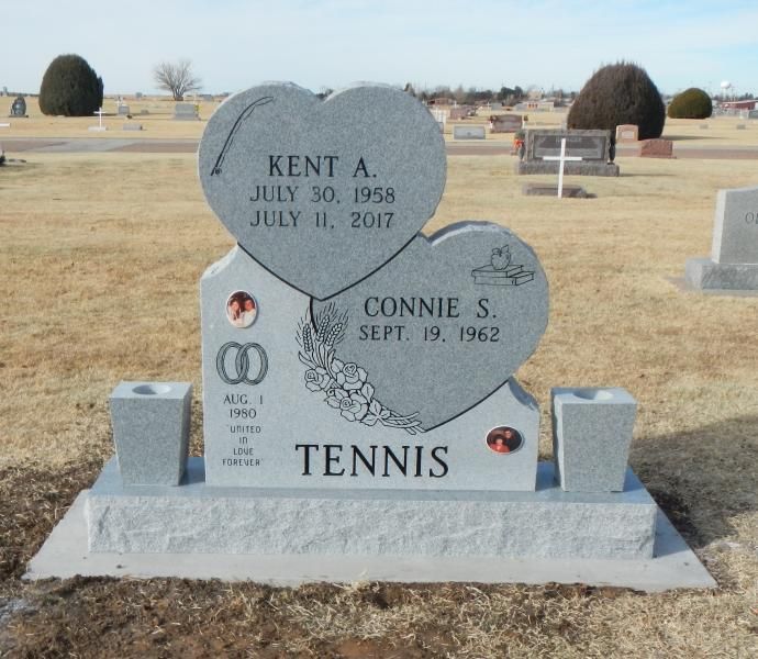 Gravestone in a cemetery for Kent A. and Connie S. Tennis with engraved hearts and stones.
