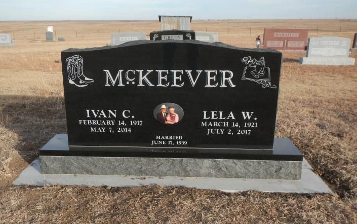 Black granite McKeever gravestone with engraved names in a dry cemetery setting