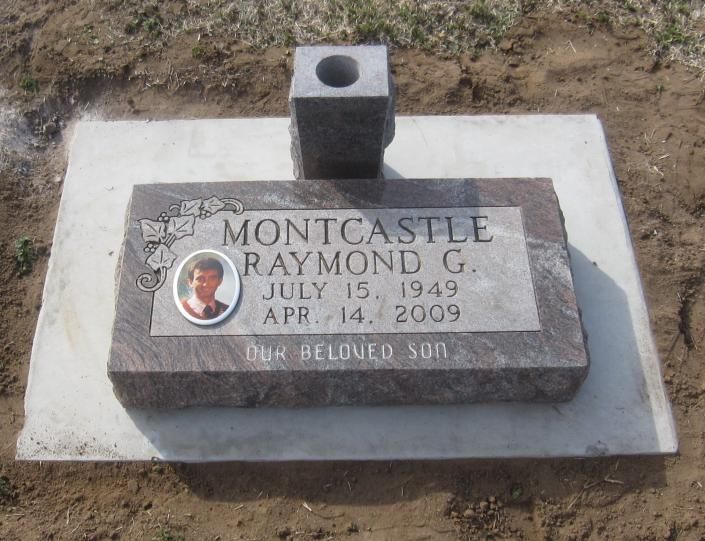 Gravestone with a portrait plaque and engraved name and dates on a concrete base outdoors.