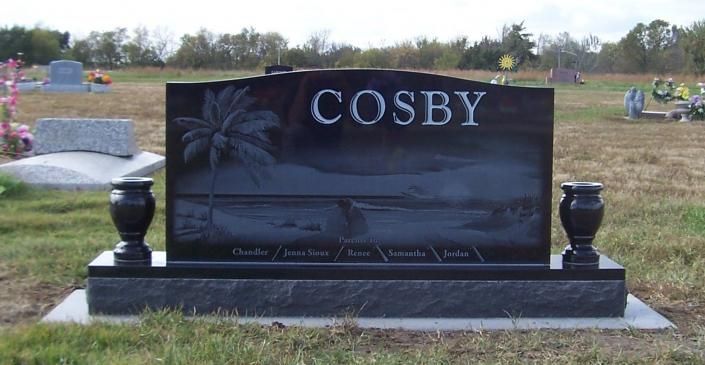 Black granite Cosby cemetery headstone with urn vases in a grassy graveyard