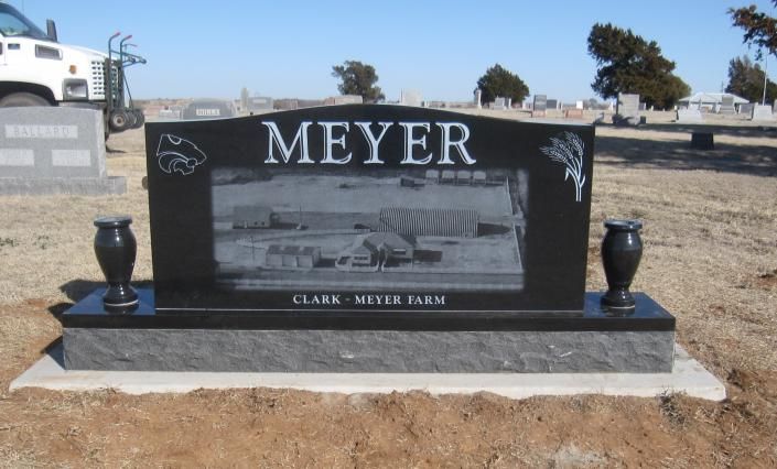 Black Meyer grave marker with engraved photo in a dry cemetery landscape