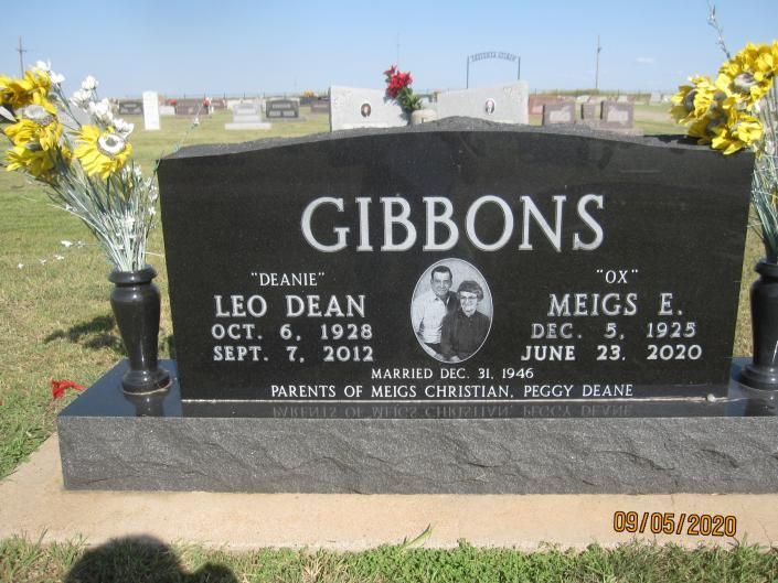 Gibbons gravestone with yellow flowers in a cemetery, honoring Dean and Migs E. Gibbons