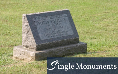 Gray granite memorial monument on a grassy lawn with “Single Monuments” logo at bottom right