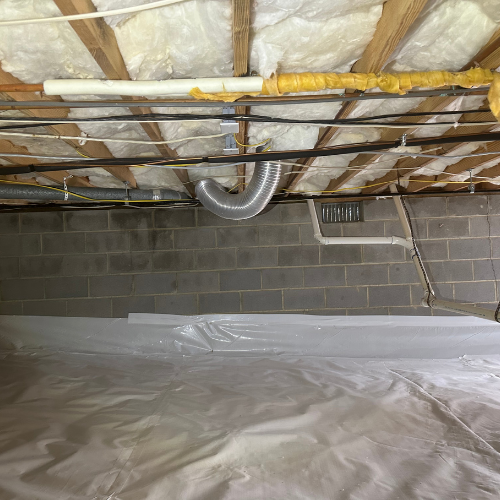 Crawlspace with a vapor barrier on the floor, insulated ceiling, and cinder block walls.
