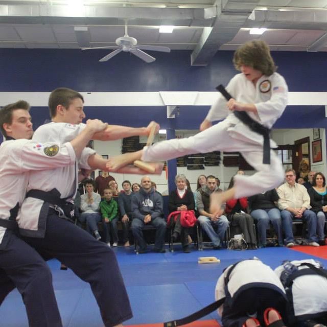 a group of people are practicing martial arts in a gym