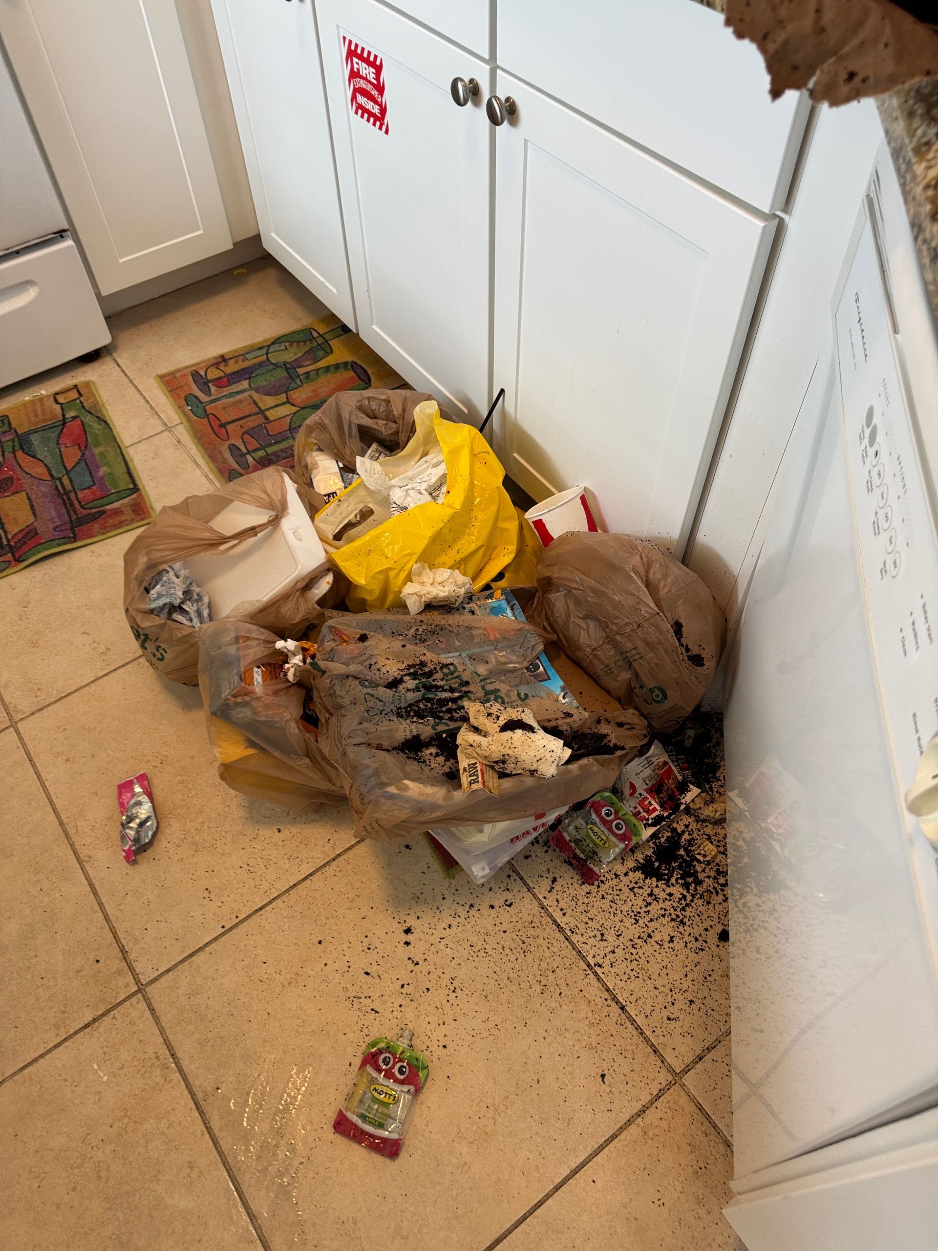 A kitchen with a lot of trash on the floor