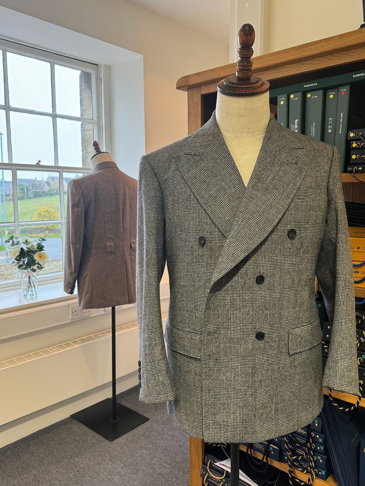 Interior of Edward George Tailoring with suits and fabric on display