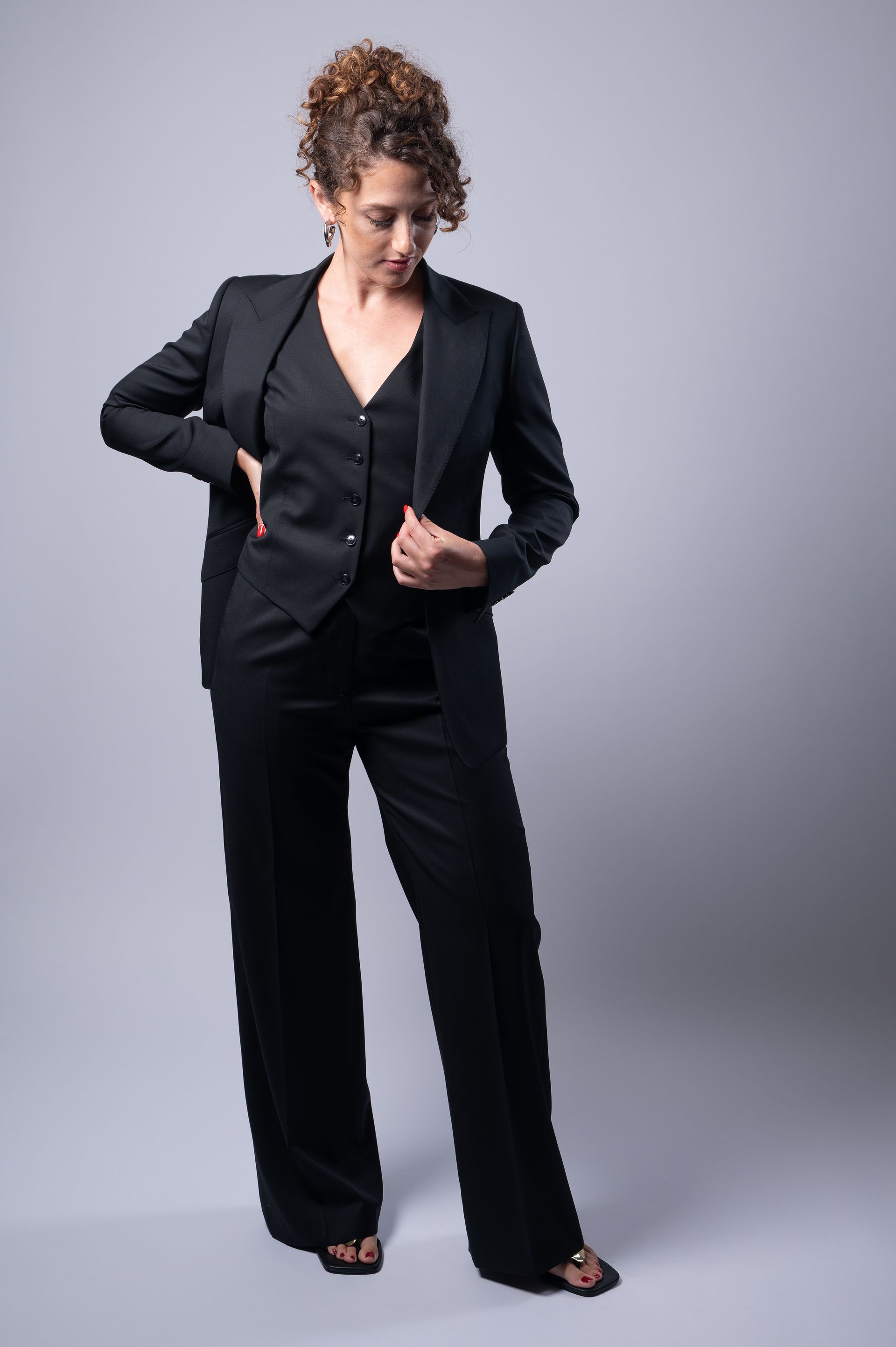 Lady wearing a black Edward George three piece suit showing off the waistcoat