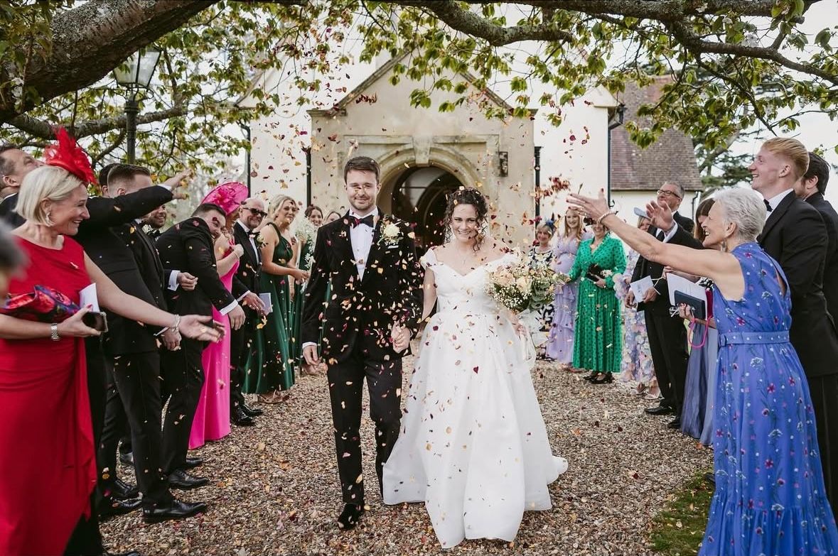 Groom wearing an Edward George velvet tuxedo jacket and black trousers for his wedding.