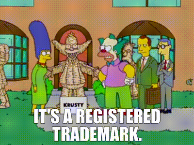 Marge, Krusty, and others stand before a burlap Krusty statue; 