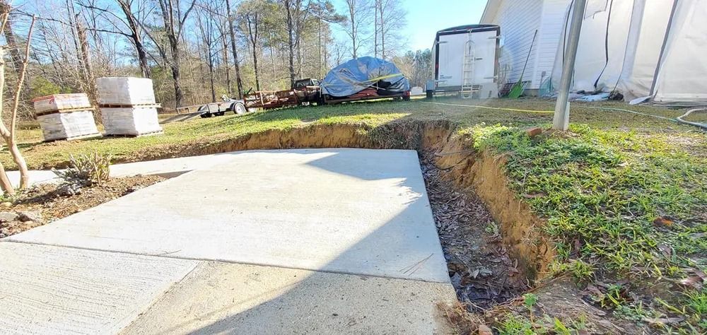 Concrete slab next to a grassy embankment, construction site setting.