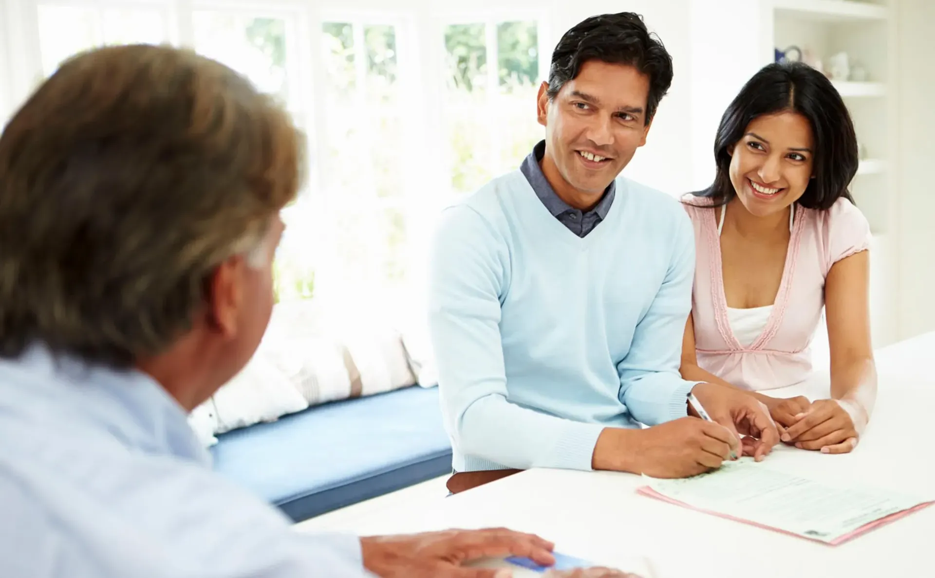 A man is sitting at a table with a woman and a man.