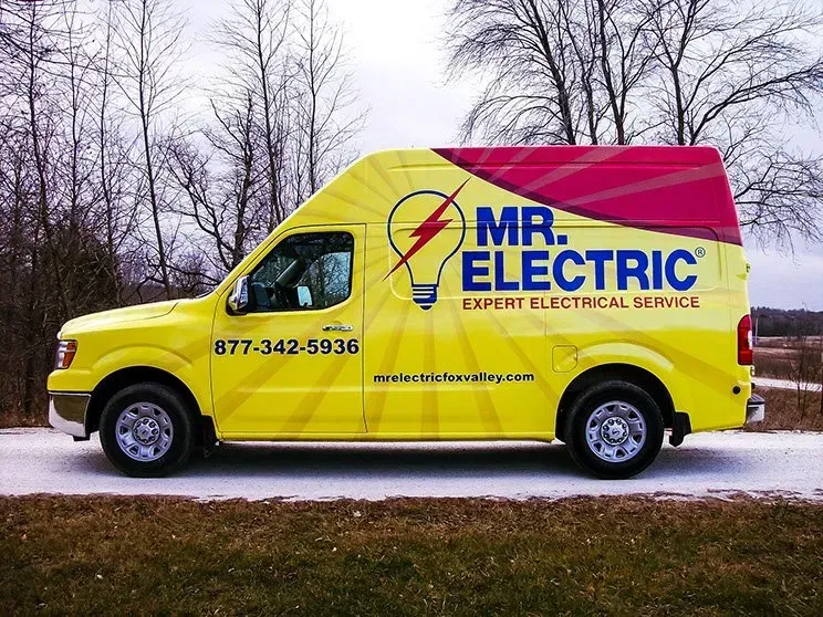 A mr. electric van is parked on the side of the road