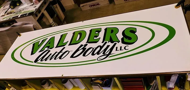 A large sign that says ' valders auto body llc ' on it