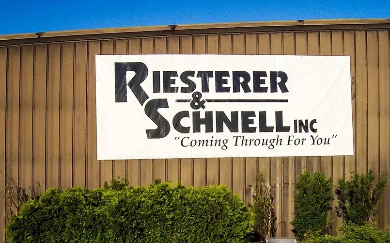 A sign on the side of a building that says riester & schnell inc