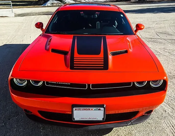 A red dodge challenger is parked in a parking lot