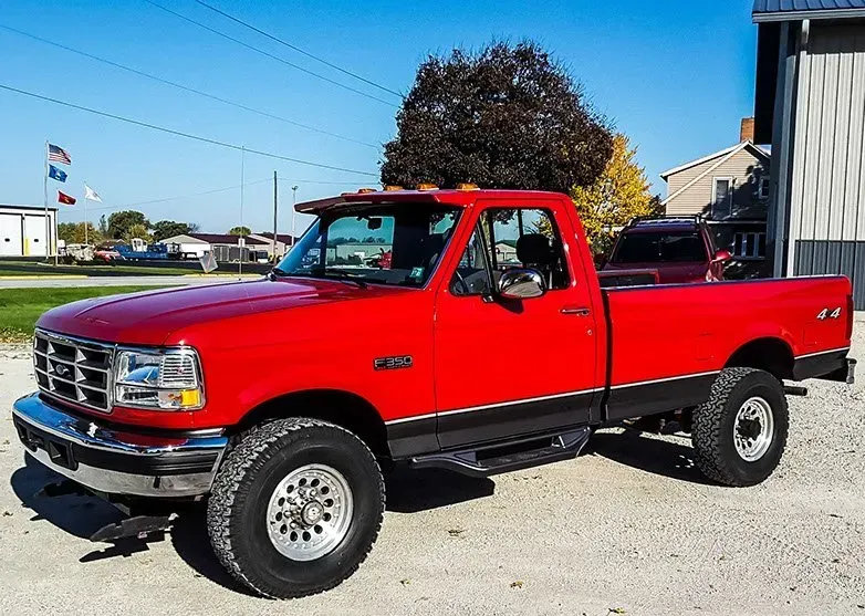 A red truck is parked in front of a building