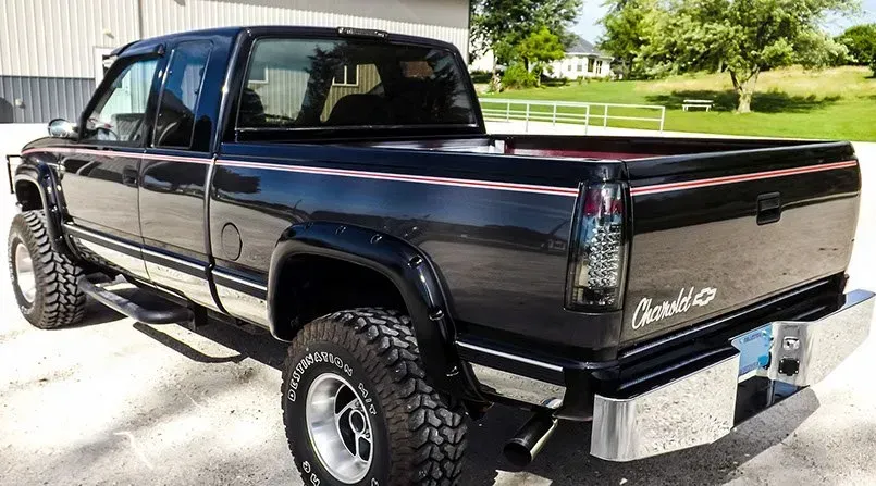 A black truck is parked in front of a building.