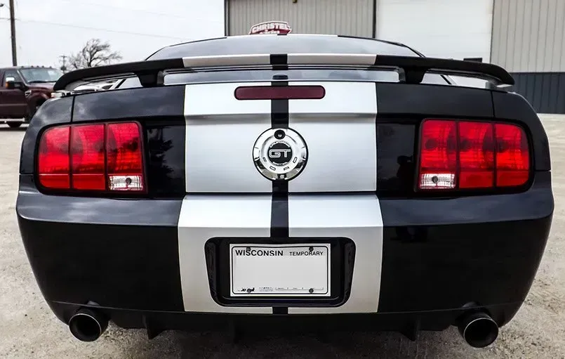 A black and white gt mustang is parked in a parking lot