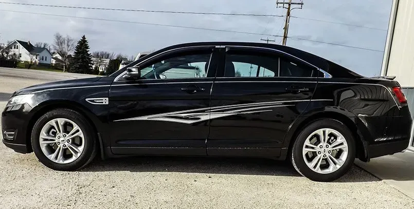 A black car is parked on the side of the road.
