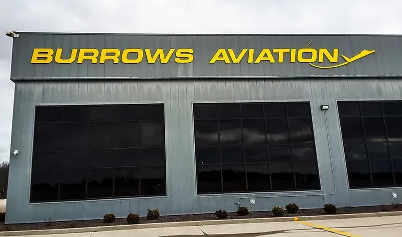 A large building with a yellow sign that says burrows aviation