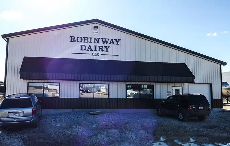 A robin way dairy building with cars parked in front of it