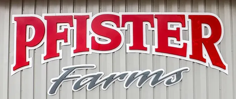 The logo for pfister farms is on the side of a building.