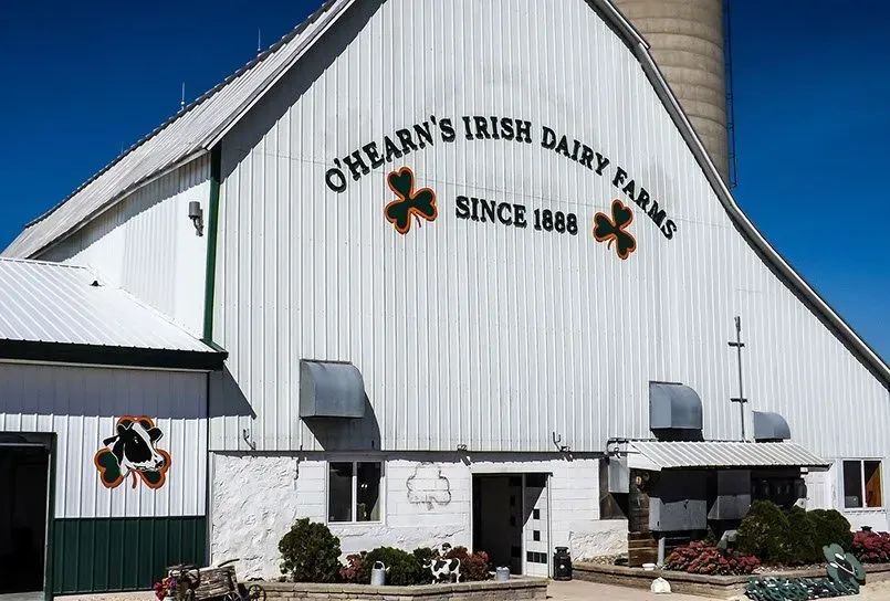 A white barn with a sign that says o'hearn 's irish dairy farms
