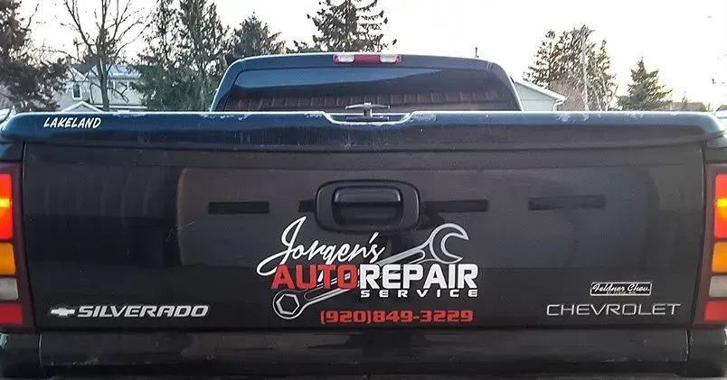 A black truck with a sticker on the back that says johnson 's auto repair