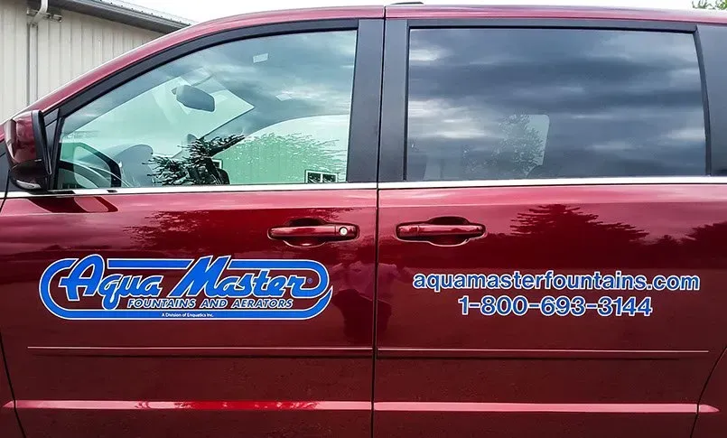 A red minivan with aqua master written on the side
