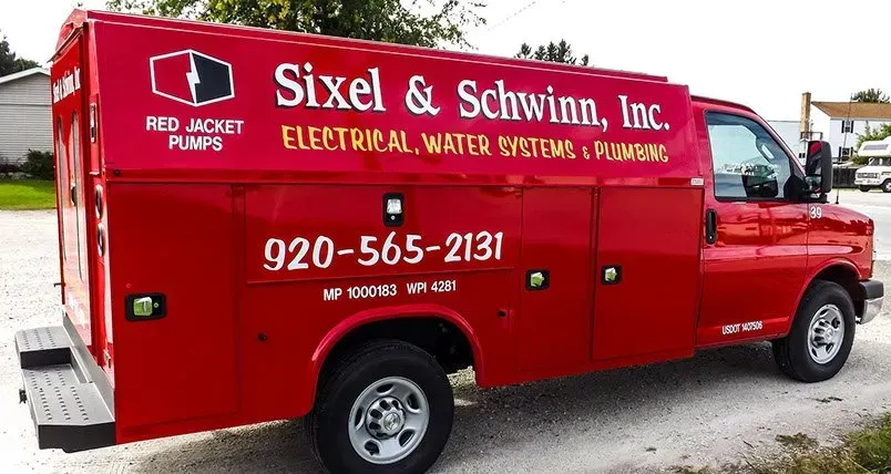 A red van for sixel & schwann inc. is parked on the side of the road