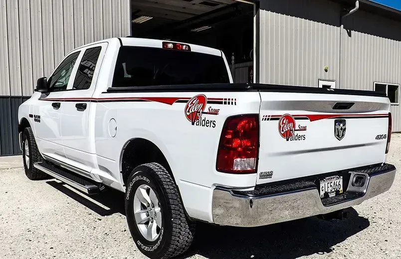 A white truck is parked in front of a building.