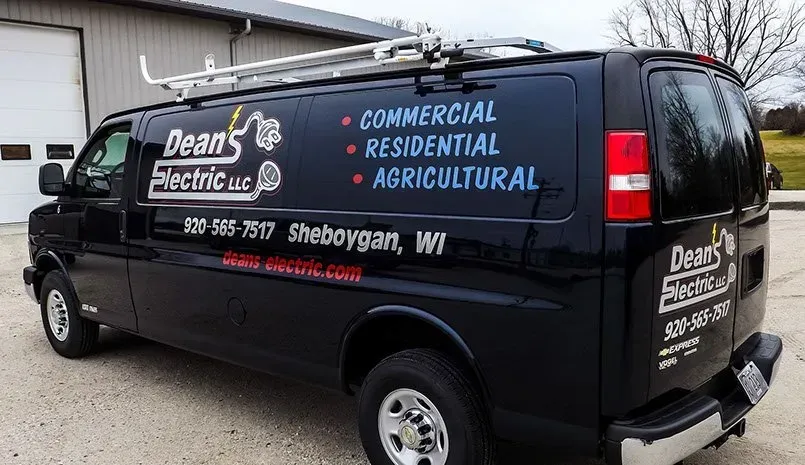 A black van is parked in front of a building.