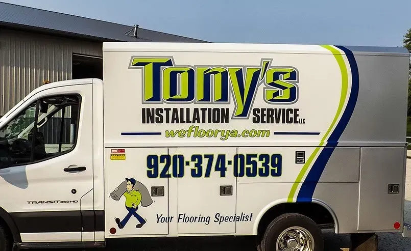 A tony 's installation service truck is parked in front of a building