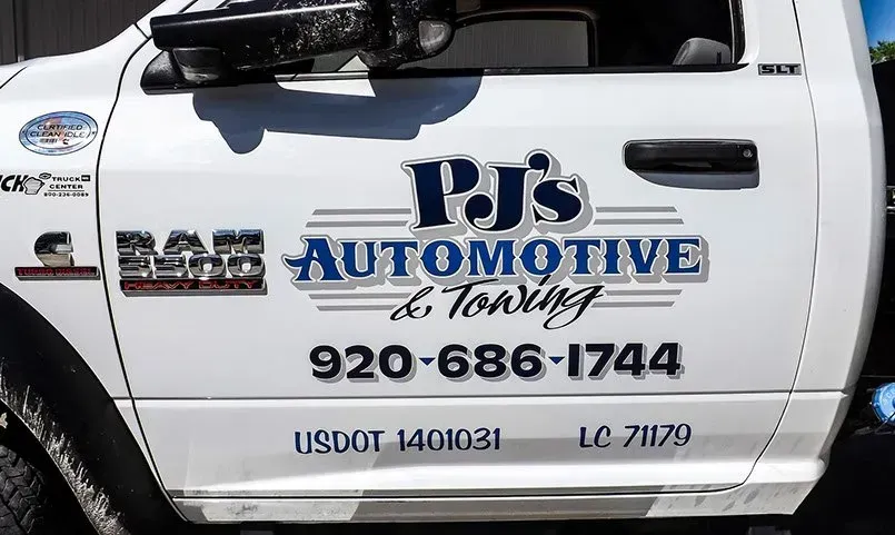 A white truck with a sticker on the side that says pj 's automotive & towing