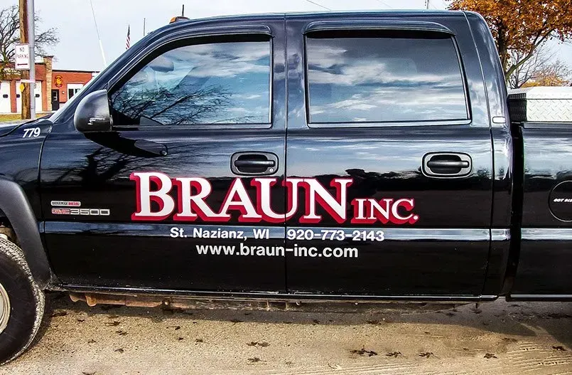 A black truck with braun inc written on the side