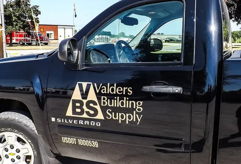 A black truck with the words valders building supply on the side