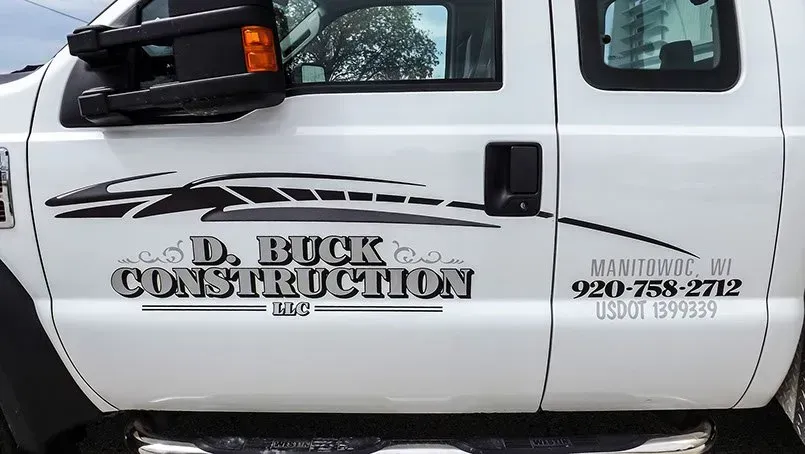 A white truck with the name d. buck construction on the side