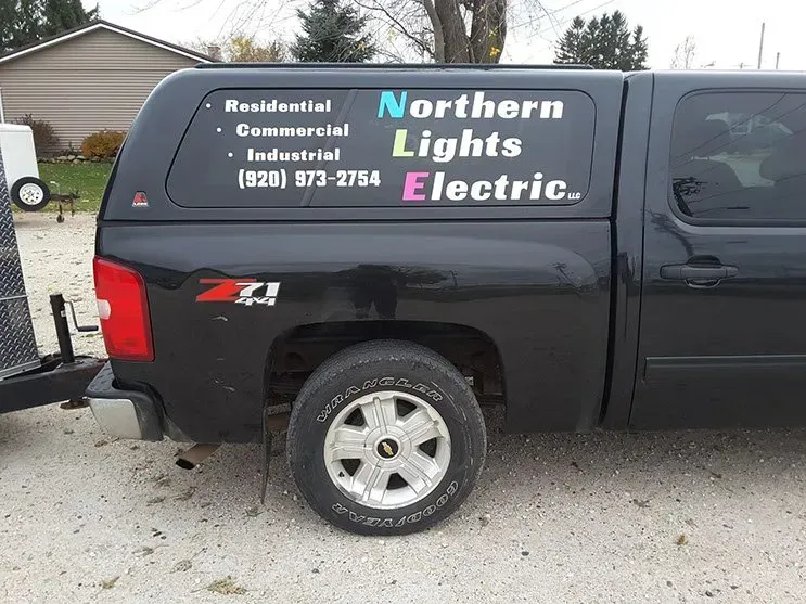 A black truck with northern lights electric written on the side