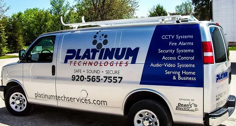 A platinum technologies van is parked on the side of the road