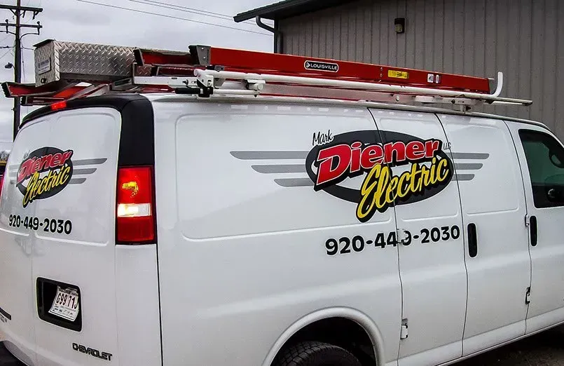 A white van with a ladder on top of it that says dinner electric